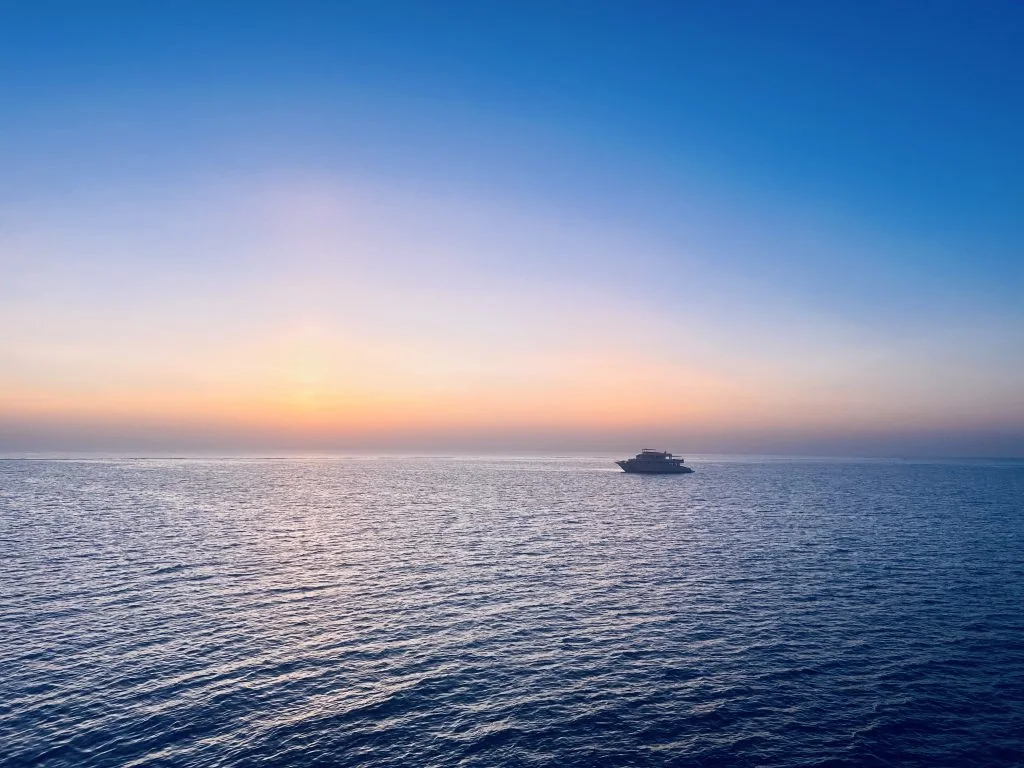 A yacht on the calm Red Sea at sunset
